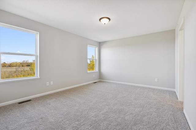 unfurnished room with baseboards, visible vents, and carpet flooring