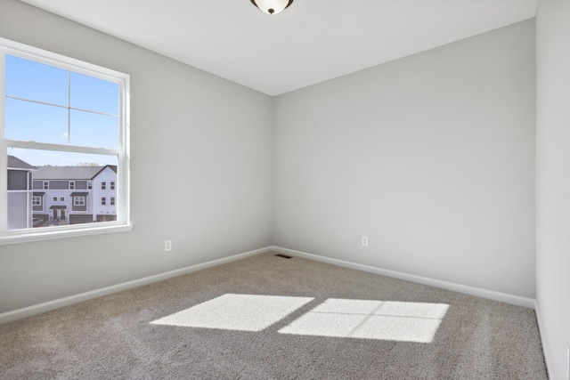 empty room featuring carpet flooring and baseboards