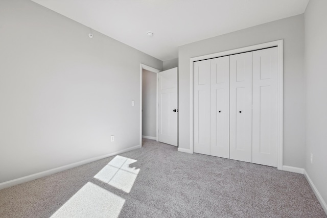 unfurnished bedroom featuring a closet, carpet, and baseboards