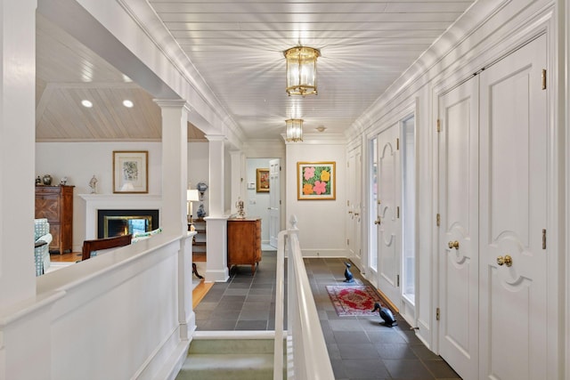 entrance foyer with baseboards, ornamental molding, recessed lighting, wooden ceiling, and a glass covered fireplace