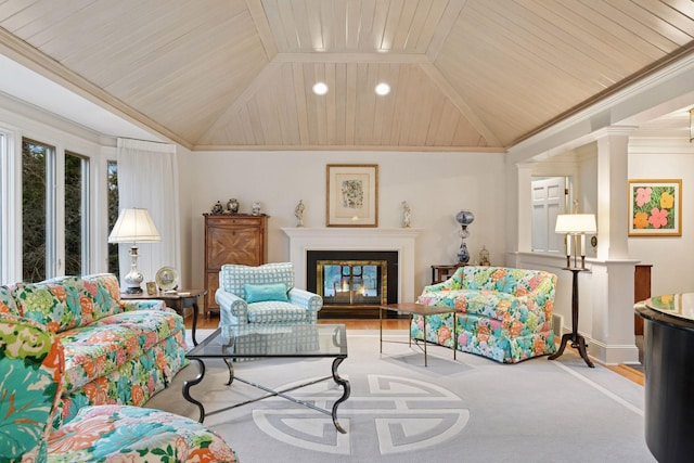 living area with ornate columns, wood ceiling, a glass covered fireplace, and vaulted ceiling