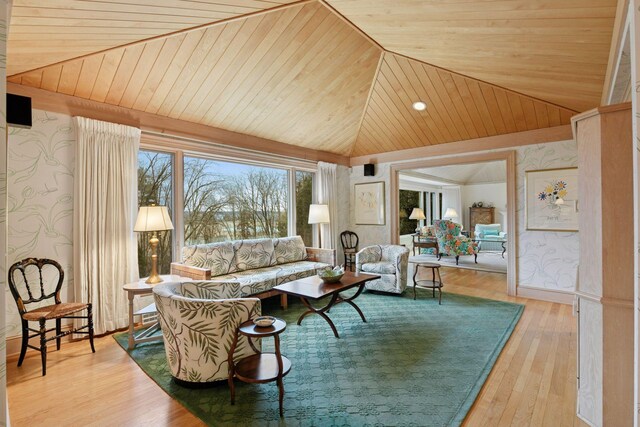 living area with wallpapered walls, lofted ceiling, wood-type flooring, and wooden ceiling