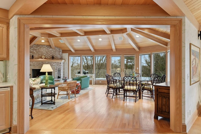 sunroom / solarium with wood ceiling, a brick fireplace, and vaulted ceiling with beams