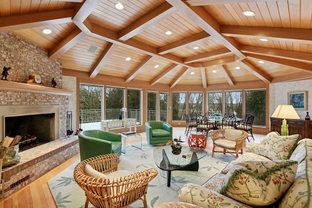 living area featuring lofted ceiling with beams, recessed lighting, wooden ceiling, a fireplace, and wood finished floors