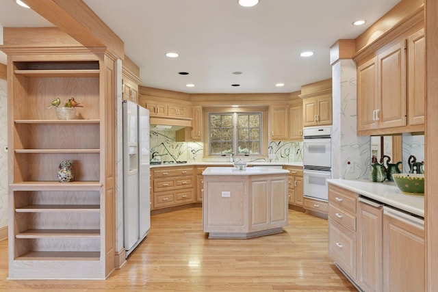 kitchen featuring light brown cabinetry, white appliances, light wood-type flooring, and light countertops