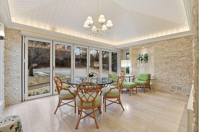 sunroom featuring vaulted ceiling, a notable chandelier, and visible vents