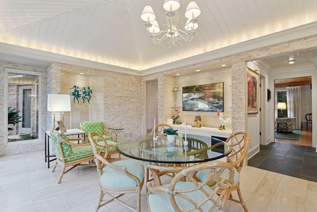 dining space with a chandelier, lofted ceiling, and ornamental molding