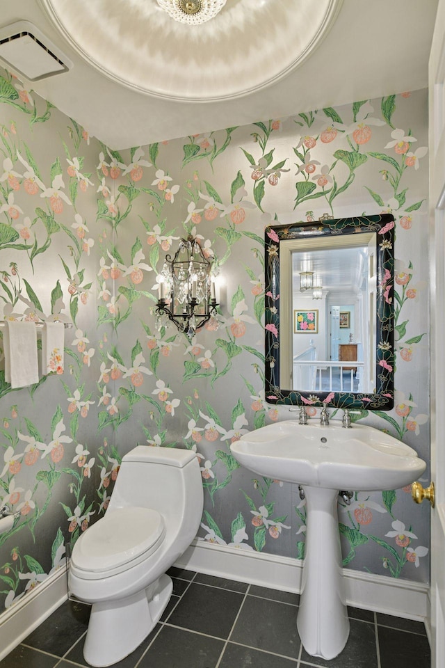 half bath featuring baseboards, toilet, tile patterned flooring, and wallpapered walls