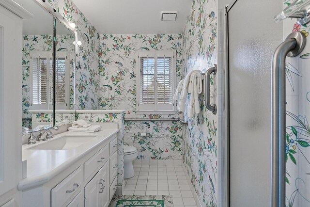 full bathroom featuring vanity, wallpapered walls, a shower stall, tile patterned floors, and toilet