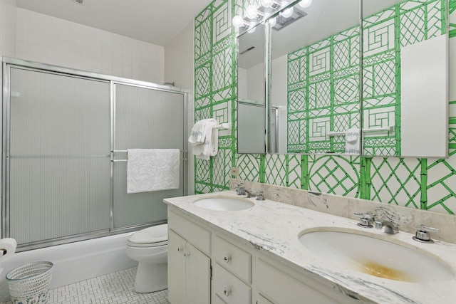 full bath featuring tile patterned flooring, combined bath / shower with glass door, toilet, and a sink