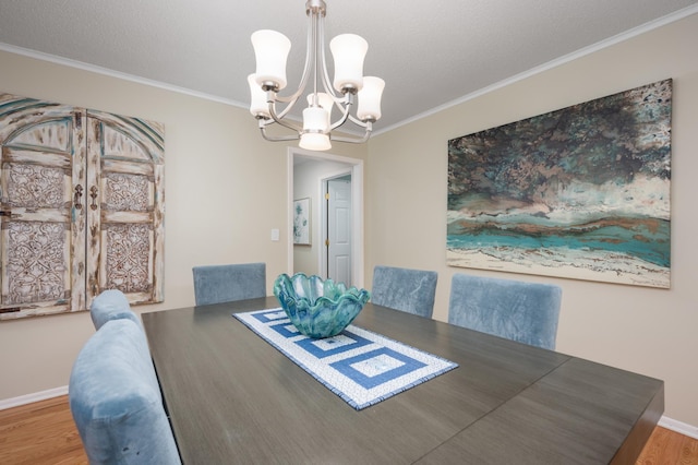 dining room featuring a chandelier, baseboards, wood finished floors, and ornamental molding