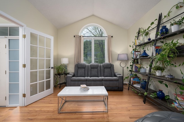 living area with light wood-type flooring and vaulted ceiling