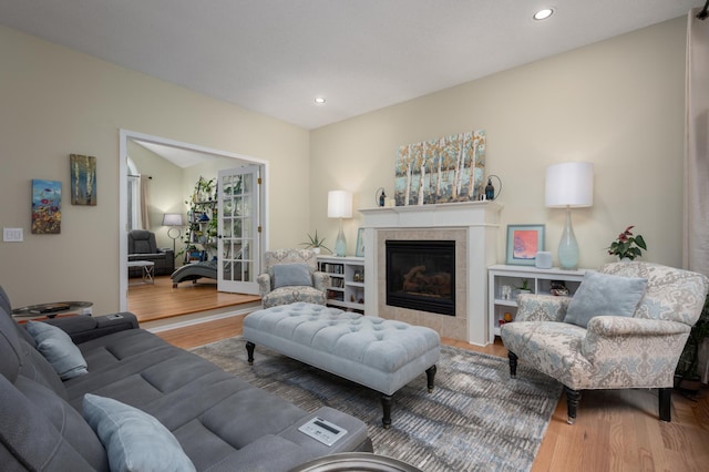 living area with recessed lighting, wood finished floors, and a tile fireplace