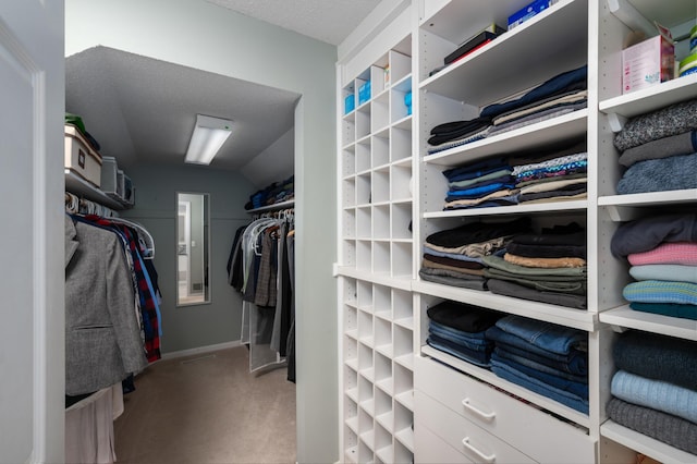 walk in closet featuring vaulted ceiling and carpet flooring