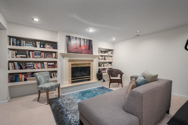 carpeted living area with visible vents, built in features, recessed lighting, baseboards, and a tile fireplace