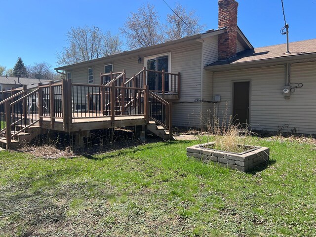 back of house featuring stairs, a lawn, a chimney, and a deck