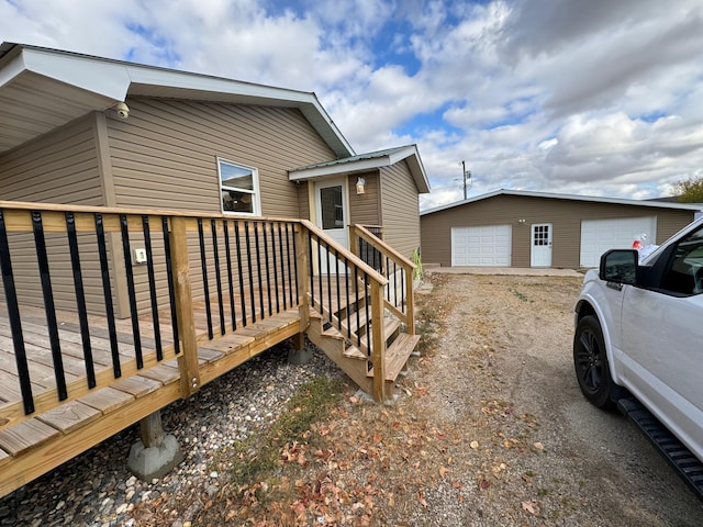 exterior space with a deck, a detached garage, and an outdoor structure