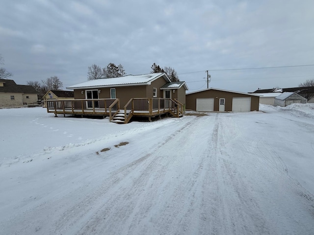 view of front of home featuring a garage, an outbuilding, and a wooden deck