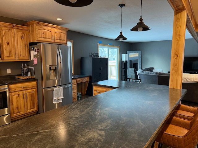 kitchen featuring brown cabinetry, dark countertops, a kitchen breakfast bar, hanging light fixtures, and stainless steel appliances