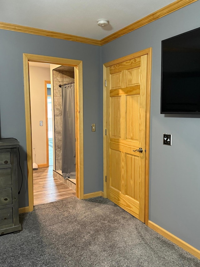 unfurnished bedroom with ornamental molding, carpet flooring, and baseboards