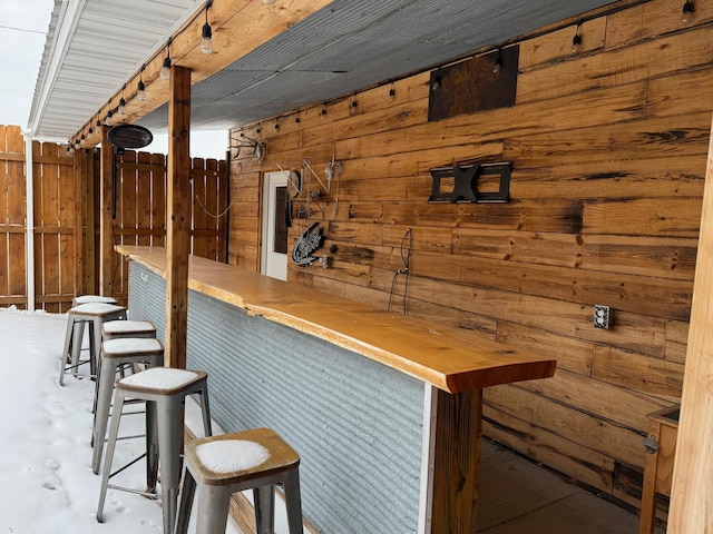 bar featuring a bar, wood walls, and concrete floors