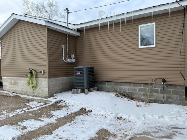 view of snowy exterior featuring cooling unit