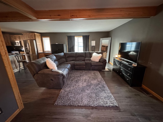 living area featuring lofted ceiling with beams, baseboards, and dark wood-style flooring