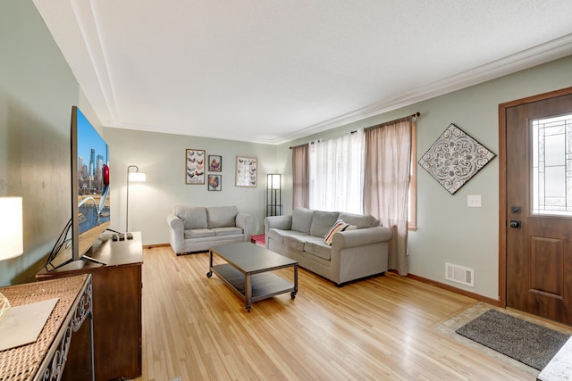 living area with light wood-type flooring, baseboards, and visible vents