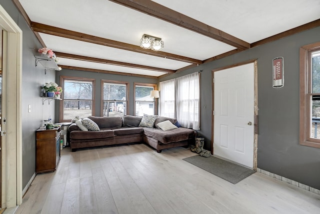 living room featuring light wood finished floors and beamed ceiling