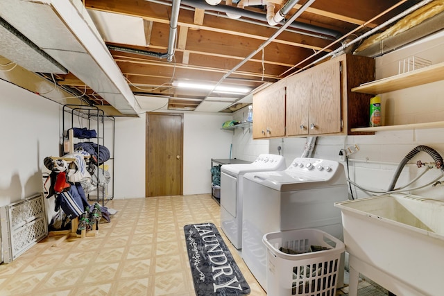 laundry area featuring tile patterned floors, cabinet space, a sink, and separate washer and dryer