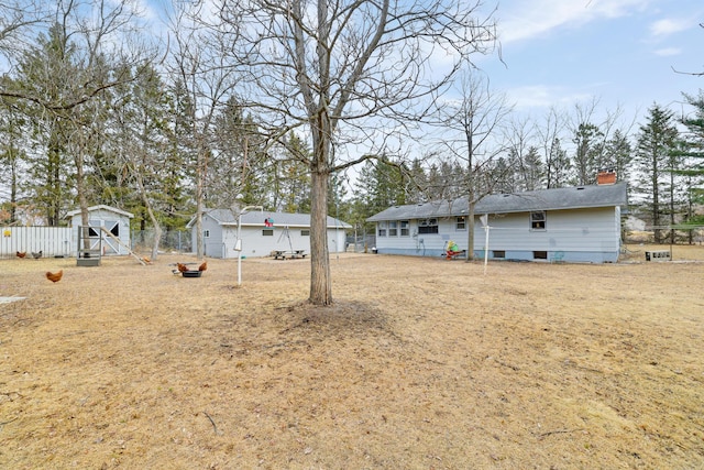 view of yard with fence and an outdoor structure