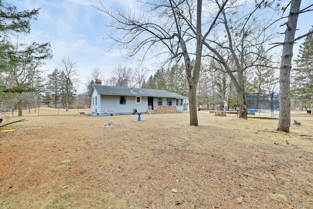 exterior space with a gazebo, a trampoline, and a chimney