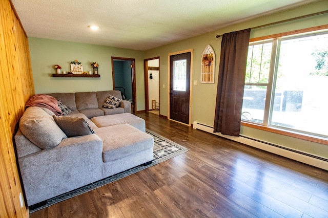 living area with dark wood finished floors, a textured ceiling, and baseboard heating