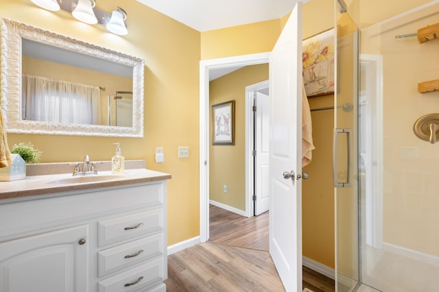 949 9th Ave SE, Rochester, MN 55904 - full bathroom featuring baseboards, a stall shower, wood finished floors, and vanity
