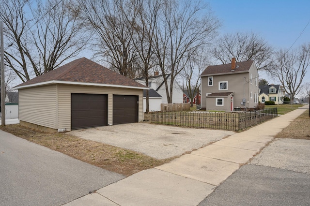 949 9th Ave SE, Rochester, MN 55904 - view of side of property with a detached garage, an outdoor structure, a shingled roof, and a fenced front yard