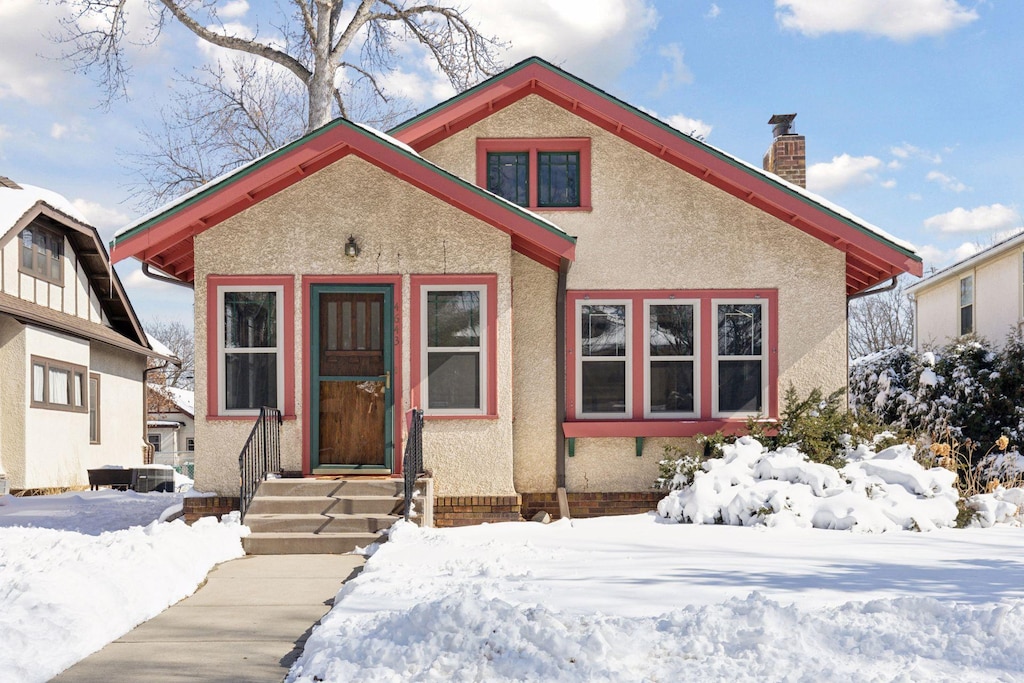 view of front of house featuring a chimney and stucco siding