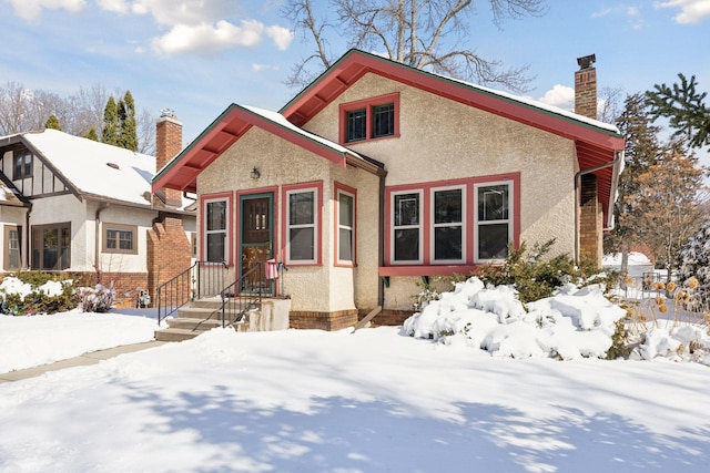 view of front of house featuring a chimney and stucco siding