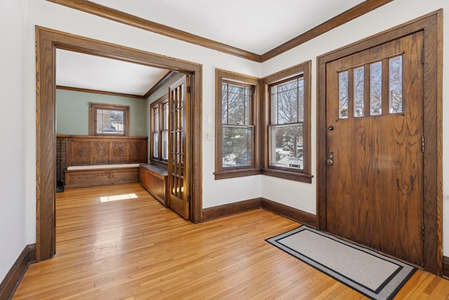 entrance foyer with light wood finished floors, ornamental molding, wainscoting, and baseboards