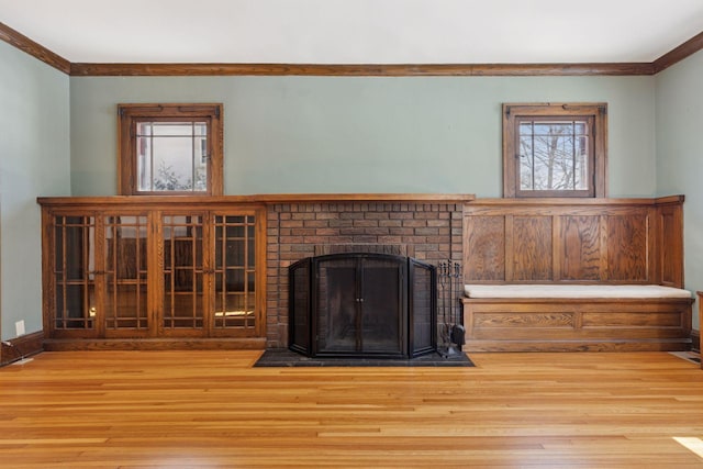 unfurnished living room with a fireplace, wood finished floors, and crown molding