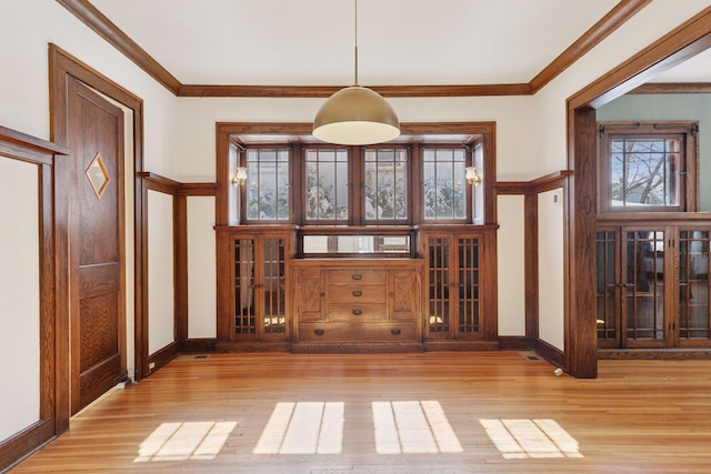 entrance foyer featuring crown molding, baseboards, and wood finished floors