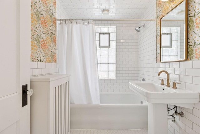 full bath featuring a wealth of natural light, shower / bath combo, tile walls, and wallpapered walls