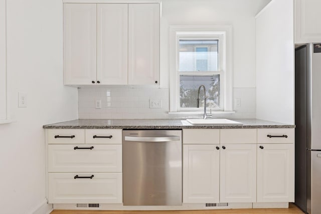 kitchen with stone countertops, visible vents, decorative backsplash, stainless steel appliances, and a sink