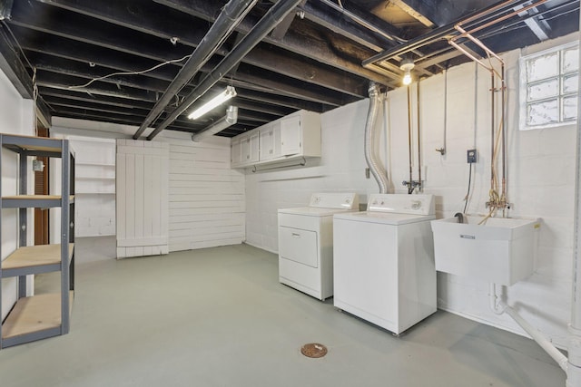 laundry room with cabinet space, a sink, and washer and clothes dryer