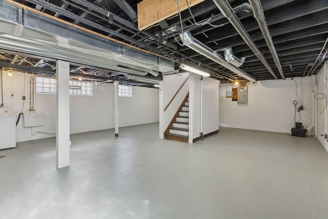 basement featuring washer / dryer, electric panel, stairway, and a sink