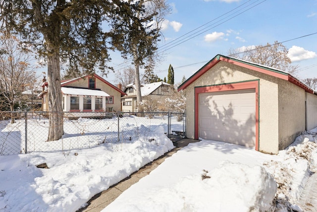 exterior space with an outbuilding, a detached garage, and fence