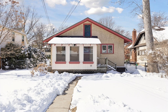 bungalow-style home with fence