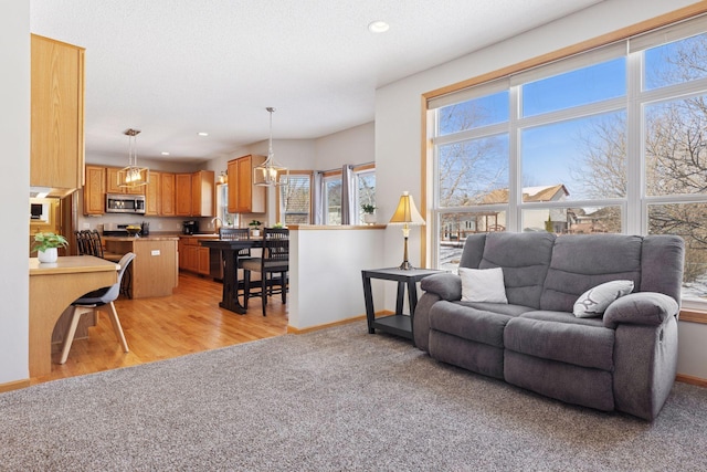 living room featuring recessed lighting, baseboards, and light colored carpet