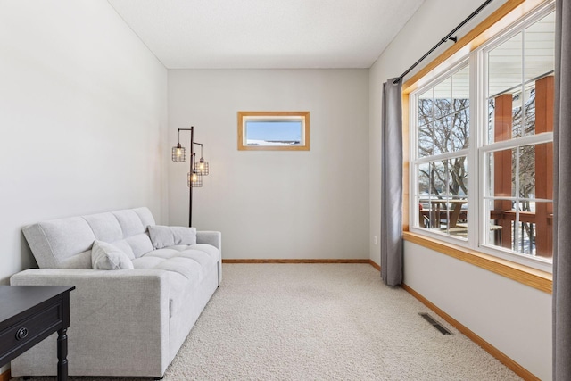 sitting room with visible vents, baseboards, and carpet floors