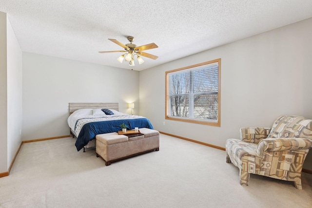 carpeted bedroom with a textured ceiling, baseboards, and ceiling fan