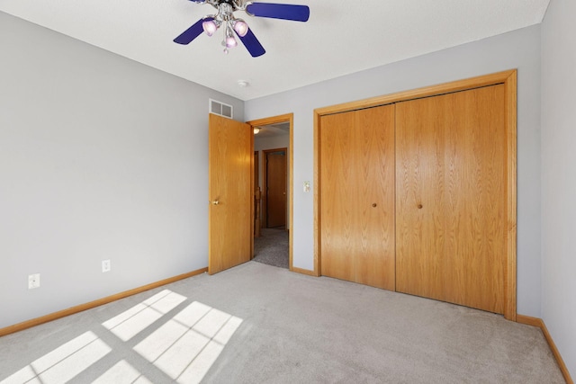 unfurnished bedroom with baseboards, visible vents, a closet, and light carpet